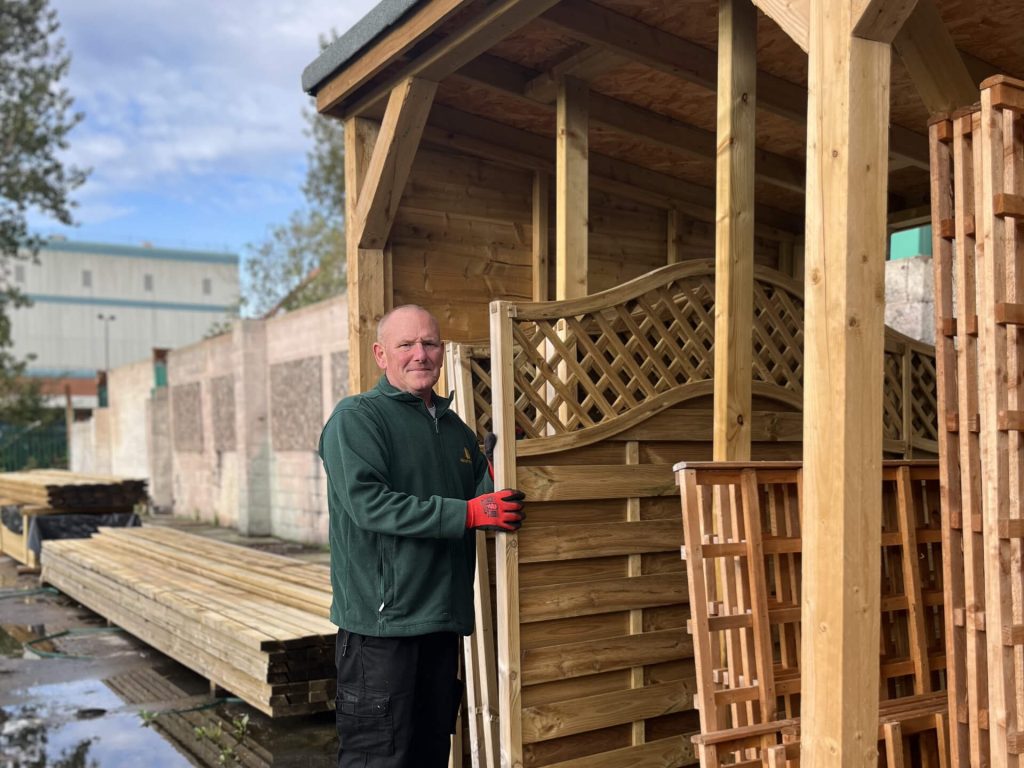 Staff member holding up fence panel